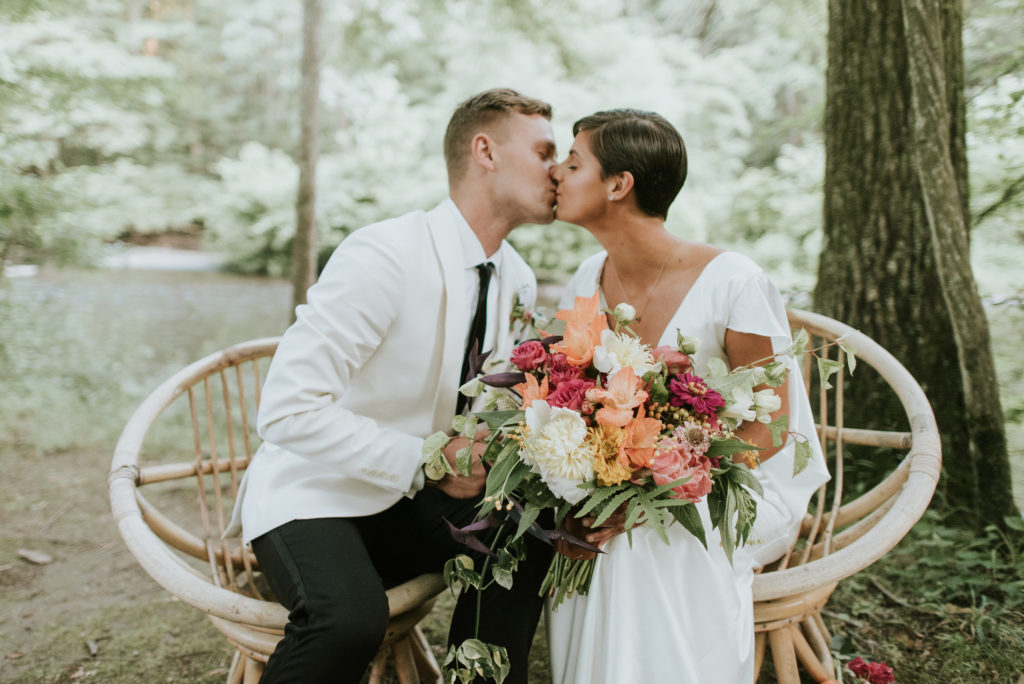 Bride and Groom with Colorful florals and Wooden Chairs