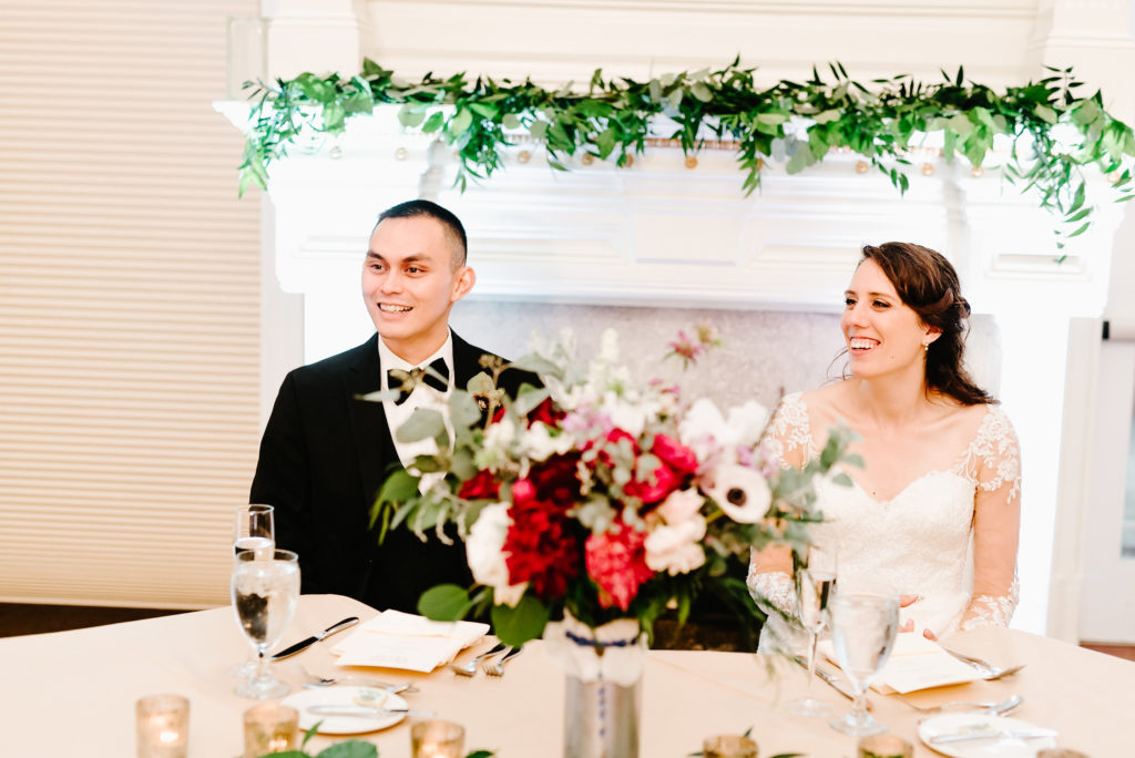 red, purple, lush greenery, stylish, wedding, sweetheart table, greenery mantle