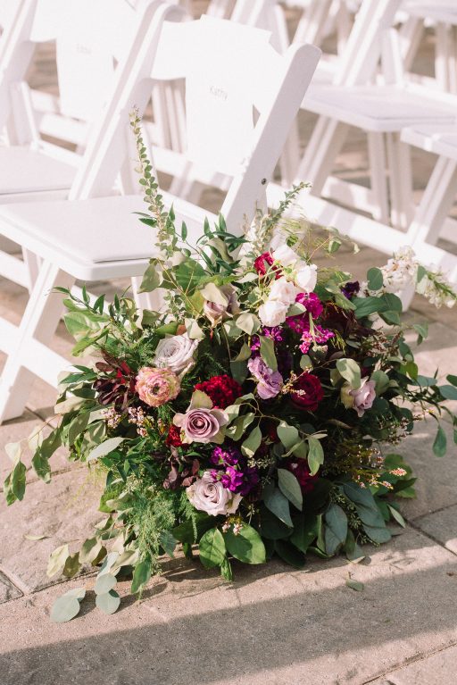 Whimsical, fall, autumn, jewel tones, gardeny, greenery, purples, blues, organic, wedding, arbor, aisle decor, aisle arrangements.