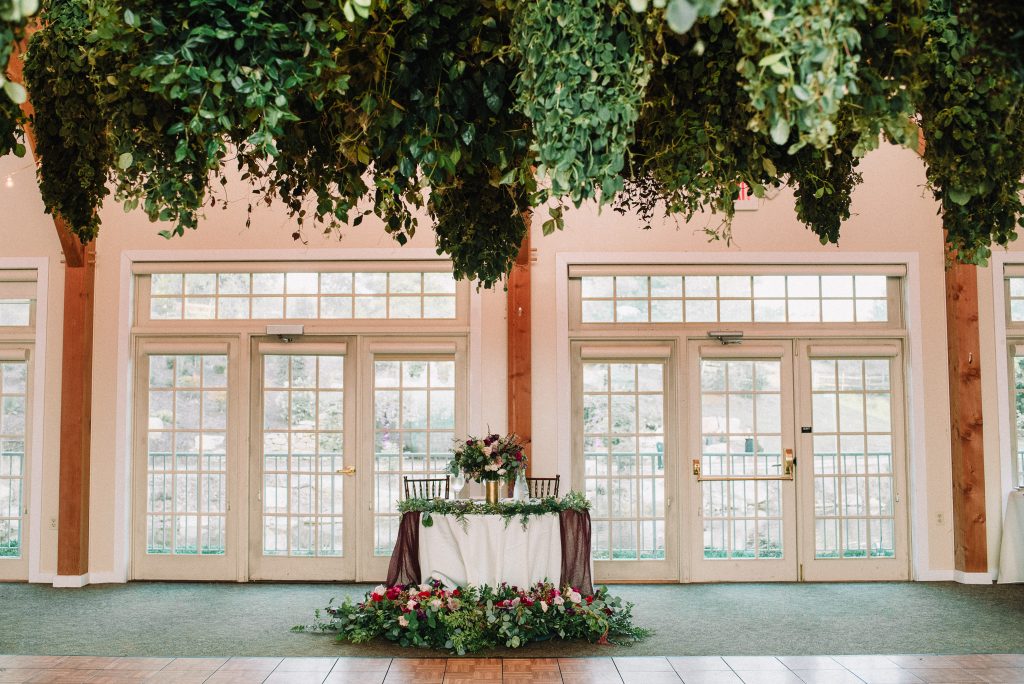 Whimsical, fall, autumn, jewel tones, gardeny, greenery, purples, blues, organic, wedding, greenery chandeliers, sweetheart table.