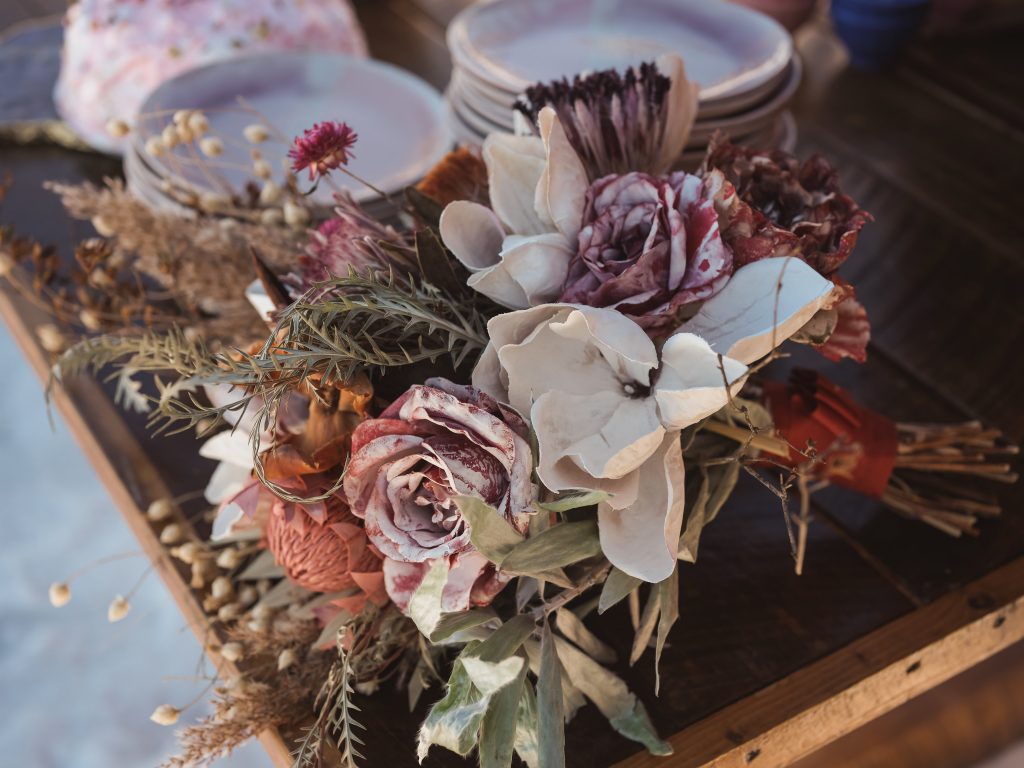 Ice wedding, ice dinner, tule bridal skirt, blush, burgundy, brown, dried florals, winter, frozen lake, styled shoot, bridal bouquet.