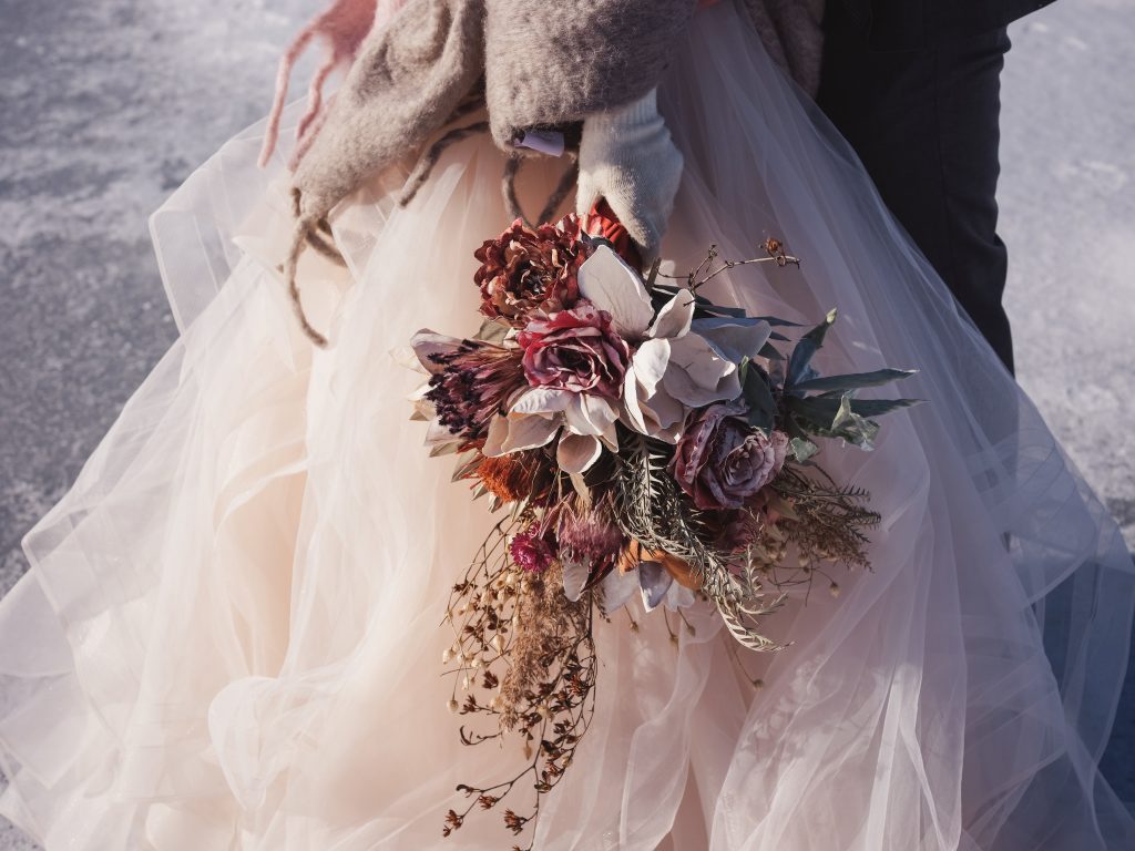 Ice wedding, ice dinner, tule bridal skirt, blush, burgundy, brown, dried florals, winter, frozen lake, styled shoot, bridal bouquet.