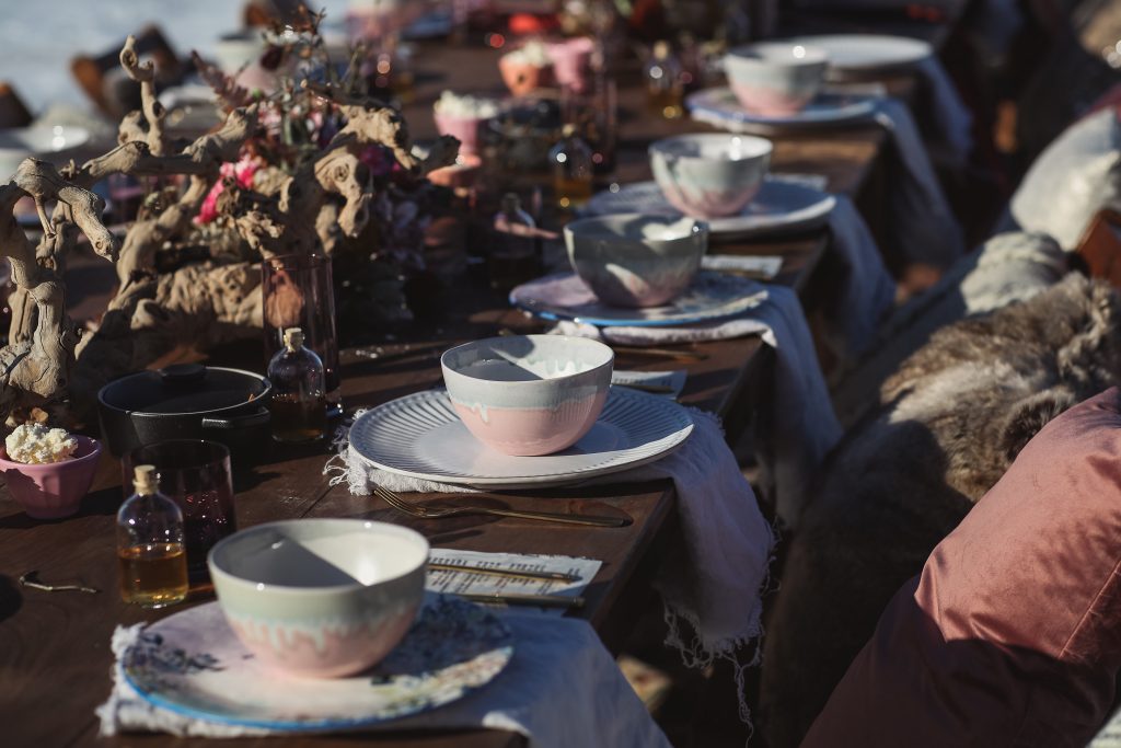 Ice wedding, ice dinner, tule bridal skirt, blush, burgundy, brown, dried florals, winter, frozen lake, styled shoot, dinner, table setting, blankets, ribbons, dried centerpiece.